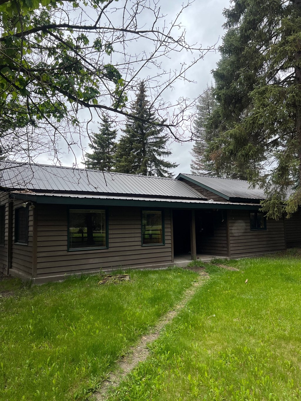a log cabin in the middle of a field with trees