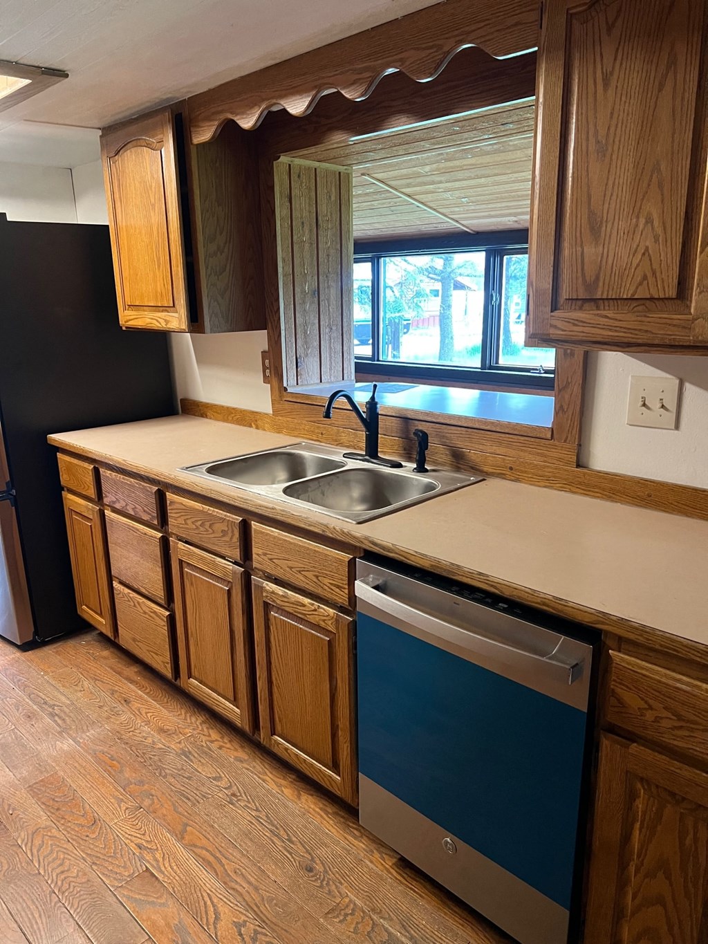 a kitchen with wooden cabinets and a sink and a window