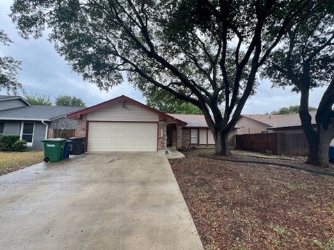 a driveway in front of a house with trees