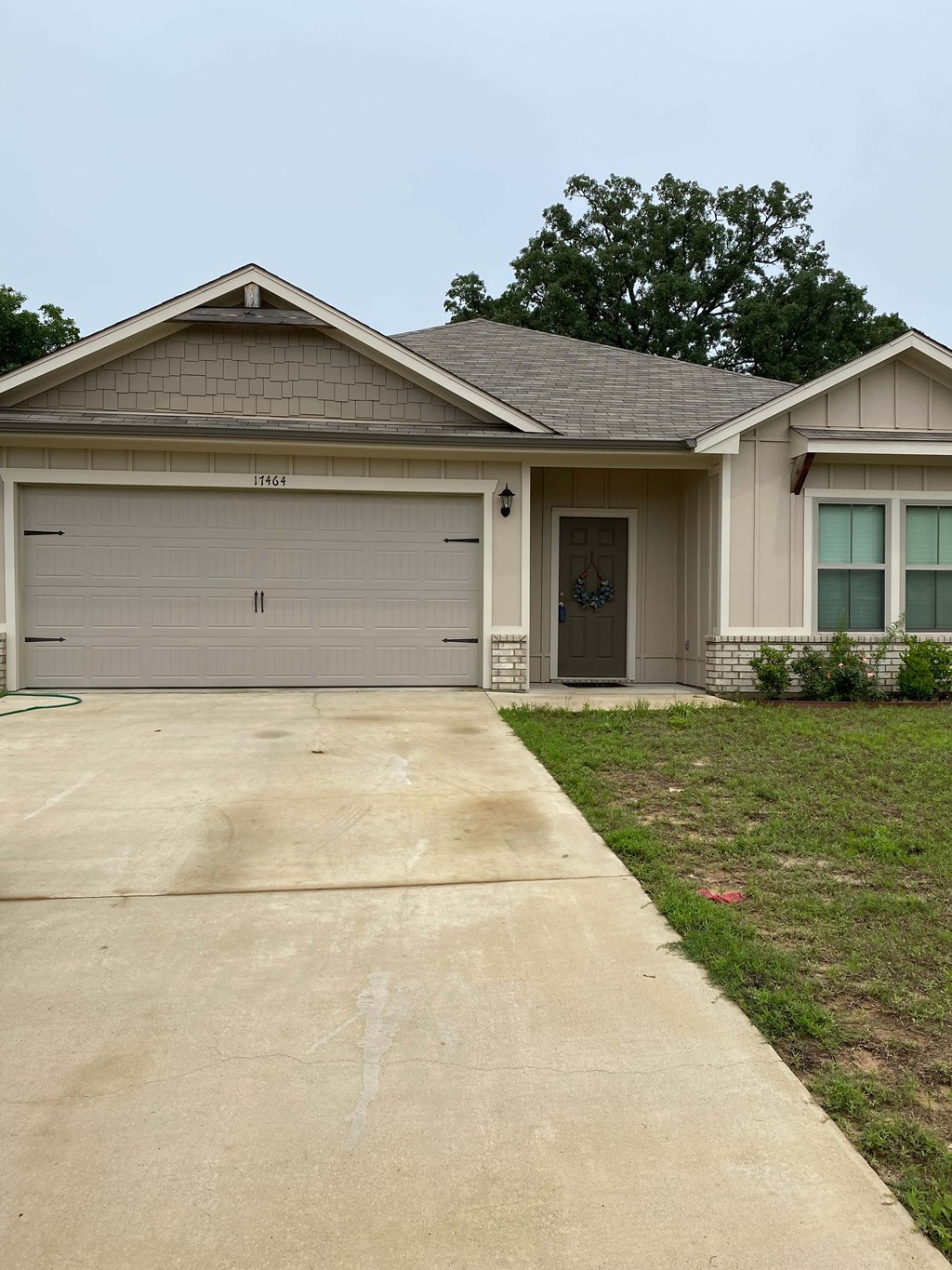 A house with a grey garage door and a brown roof.