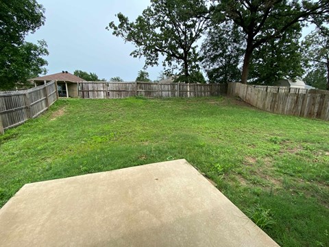 A backyard with a ramp and a fence.