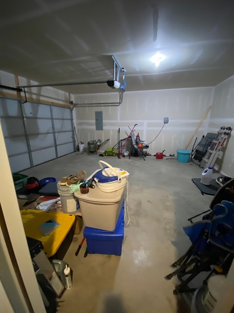 A garage with a white wall and a white ceiling with a light on it.