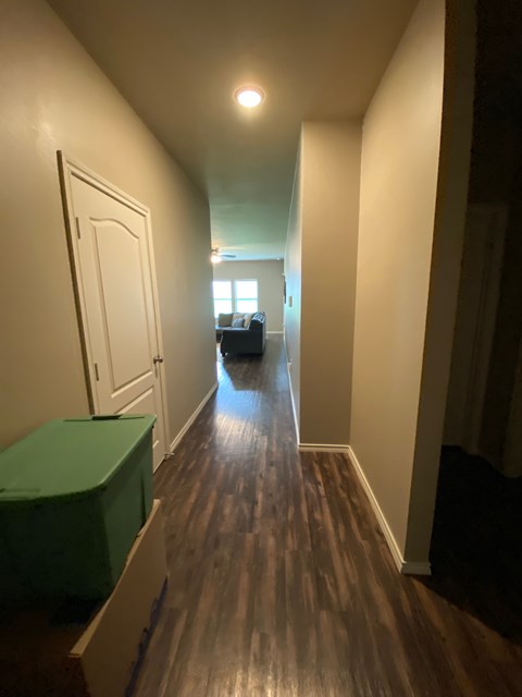 A long hallway with a green box on the floor.