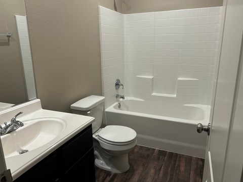 A white toilet sits next to a white sink in a bathroom.