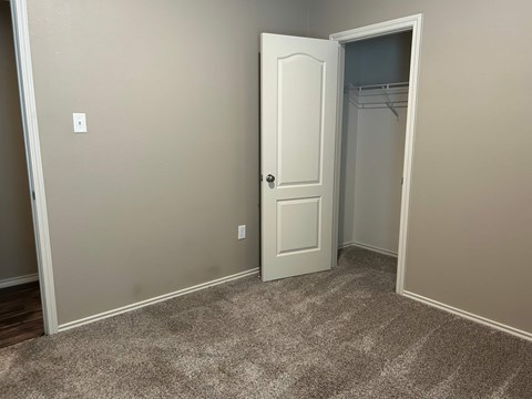 A white door is open in a room with a carpeted floor.