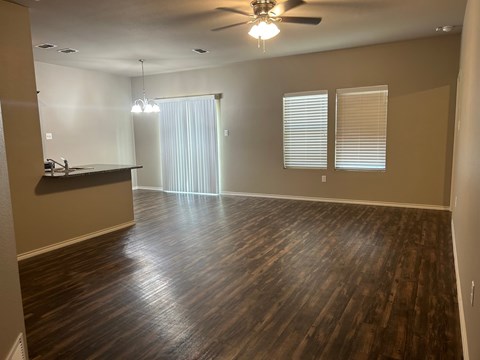 A room with wooden floors and a ceiling fan.