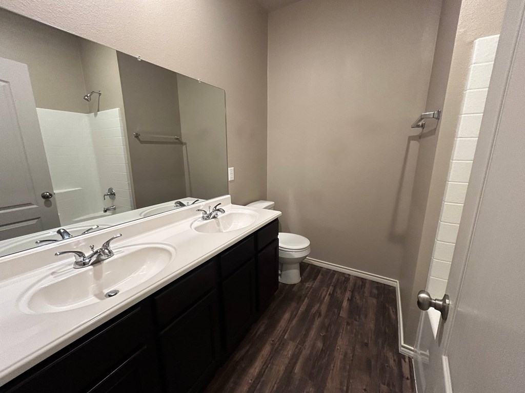 A bathroom with two sinks and a toilet.