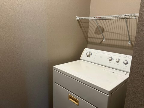 A white washing machine sits in a laundry room.