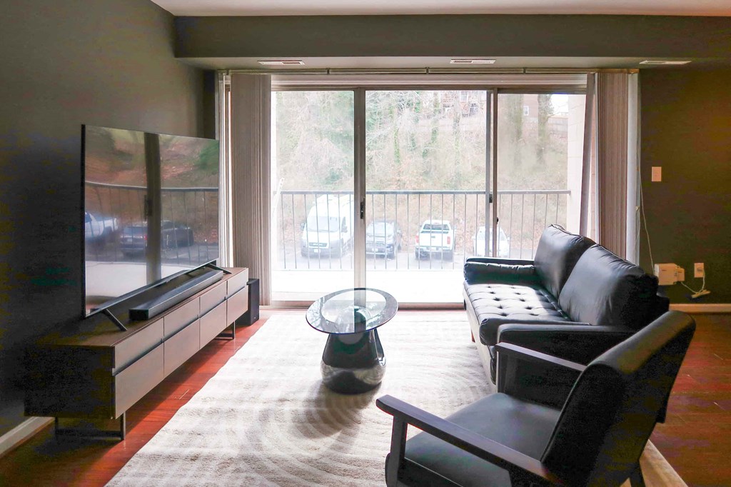 a living room with leather furniture and a large window
