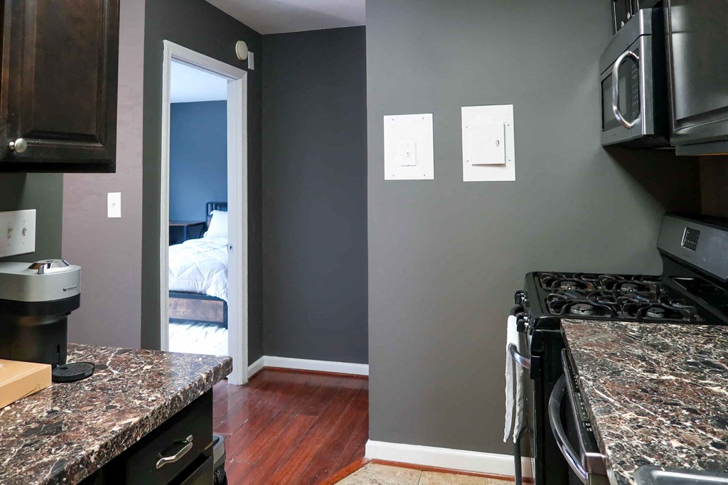 a kitchen with a stove and a door to a bedroom