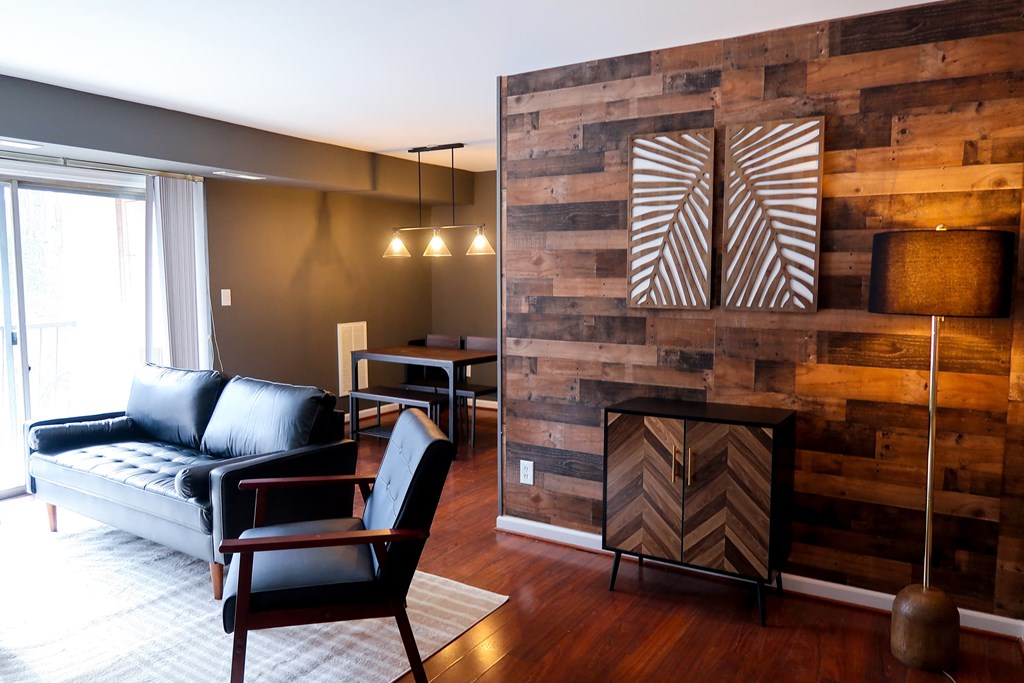 a living room with a couch and a wood accent wall