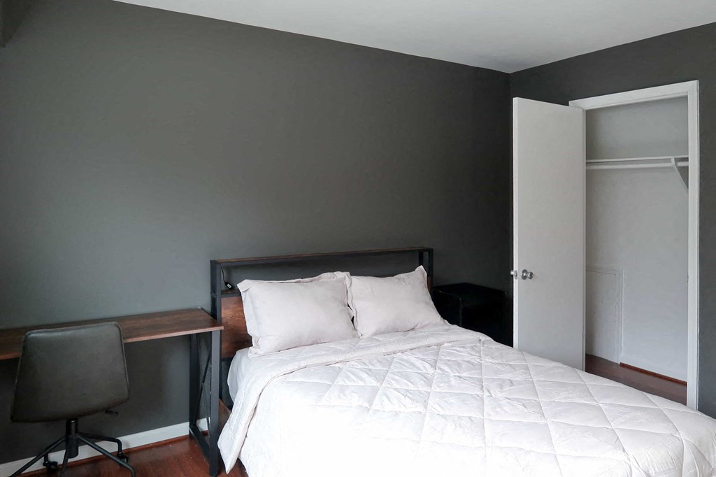 a bedroom with a bed and a desk with a chair