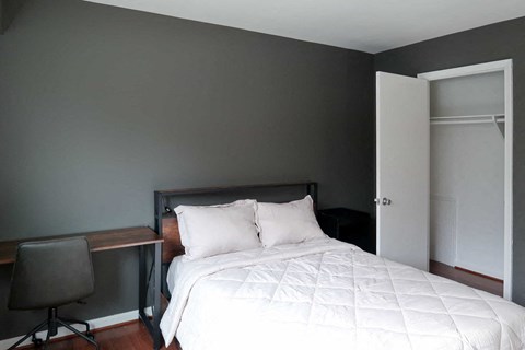 a bedroom with a bed and a desk with a chair