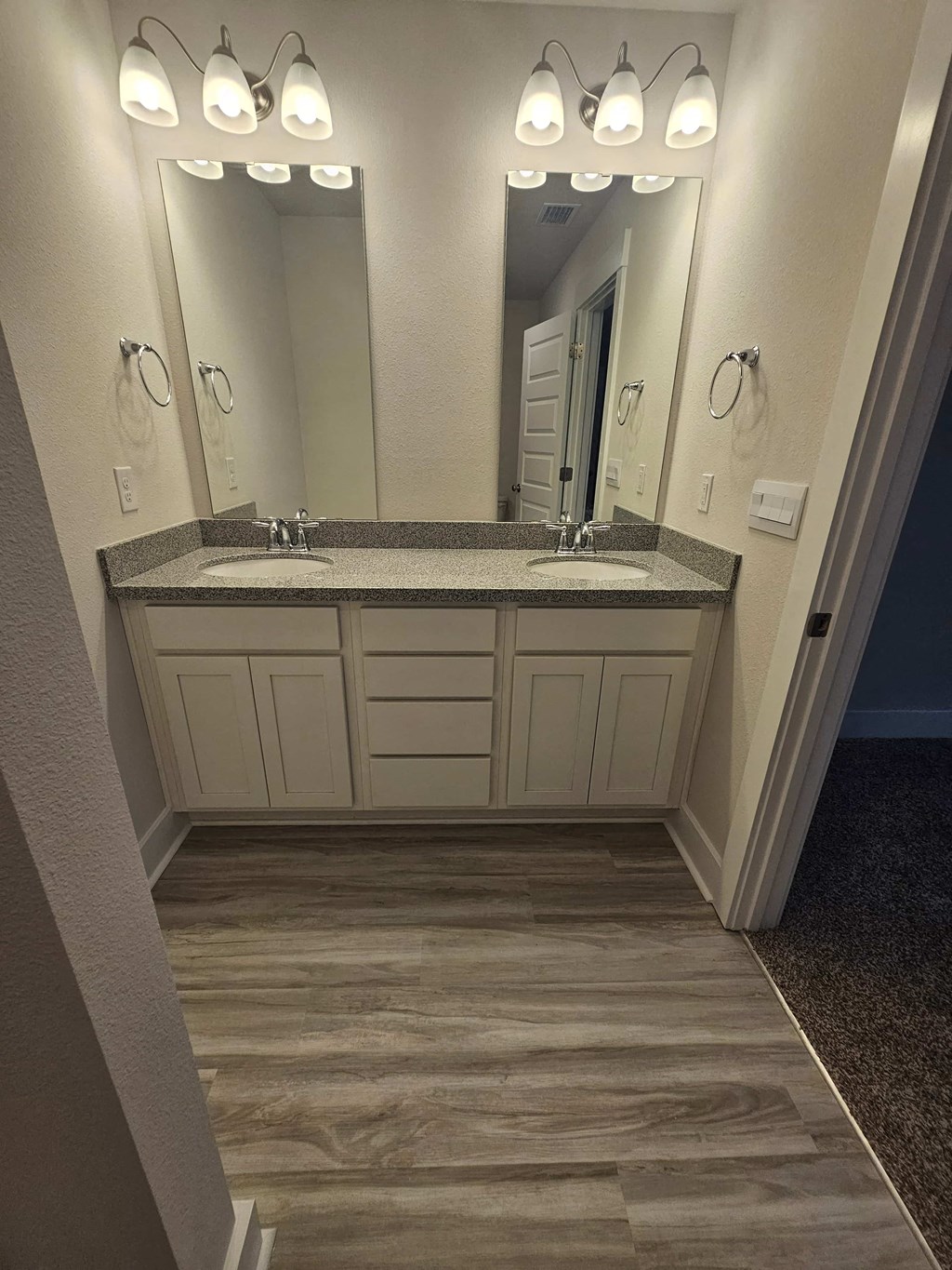 a bathroom with a sink and two mirrors