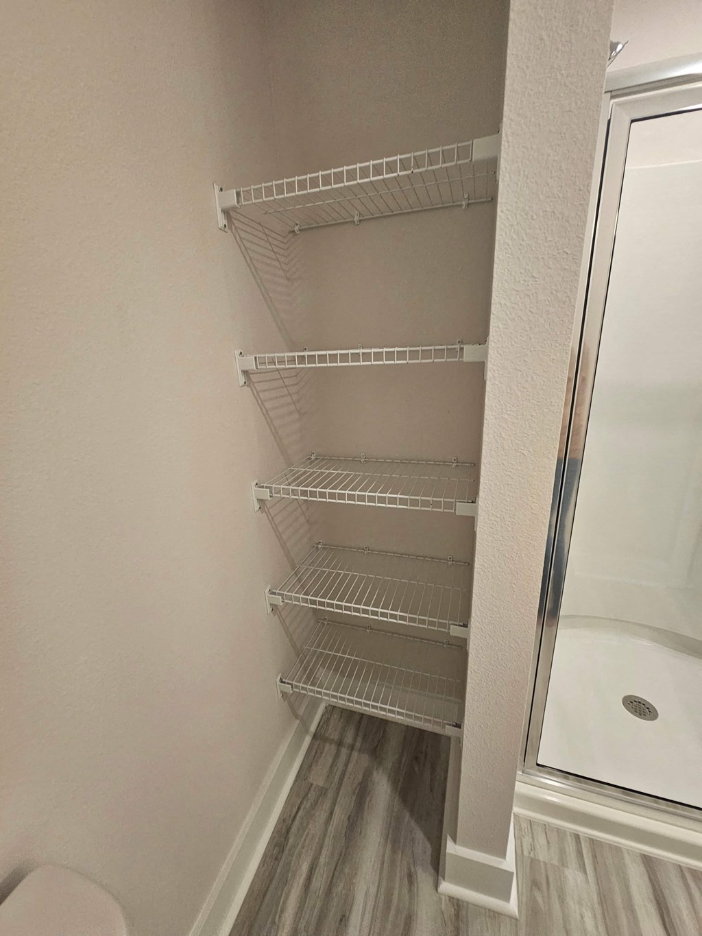 a walk in shower in a bathroom next to a closet