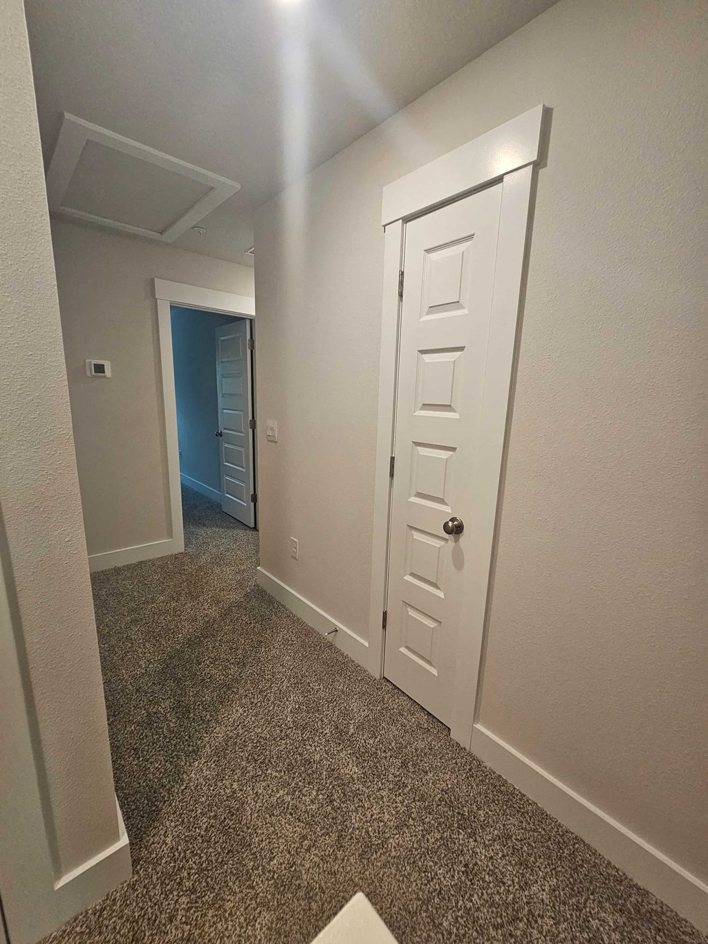 a small hallway with a closet and a door to a bedroom