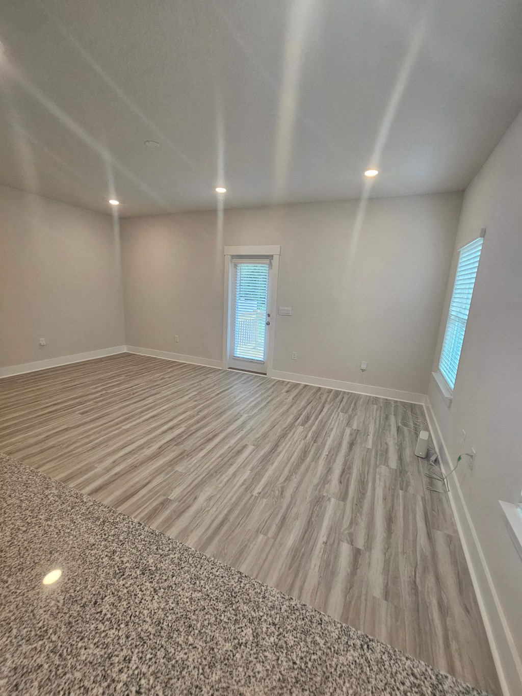 a living room with a hard wood floor and a window