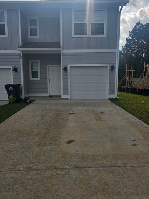 a driveway in front of a house with a white garage door