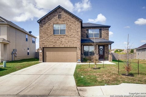 A two-story house with a garage is situated in a residential area.