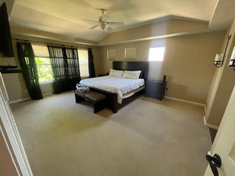 a bedroom with a bed and a ceiling fan