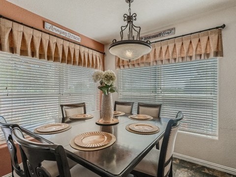 a dining room with a table and chairs and a chandelier
