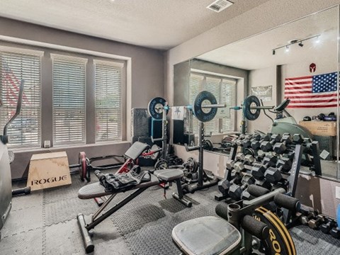 a home gym with weights and a us flag on the wall