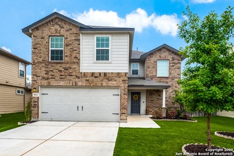 A two-story house with a garage and a driveway.