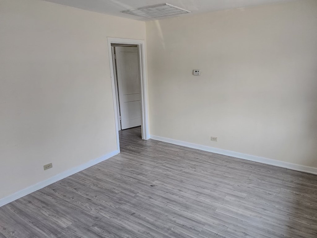 a empty room with wood flooring and white walls