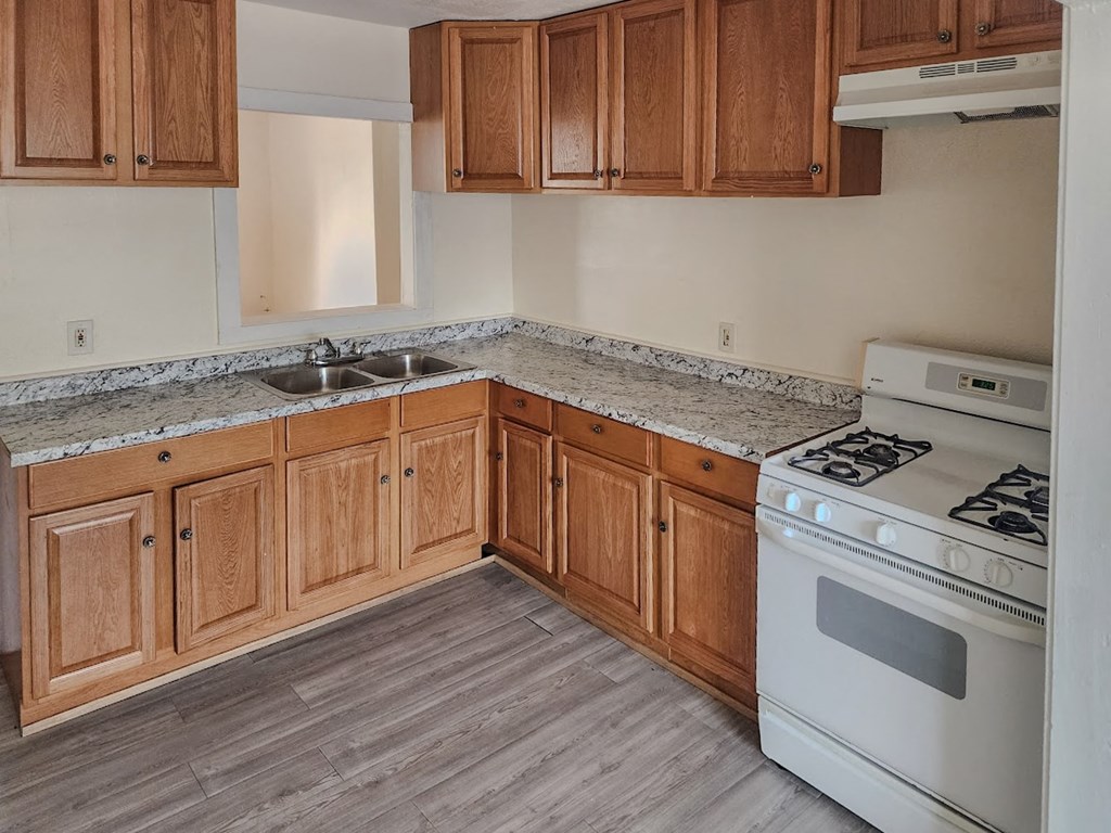a kitchen with wooden cabinets and a stove and a sink