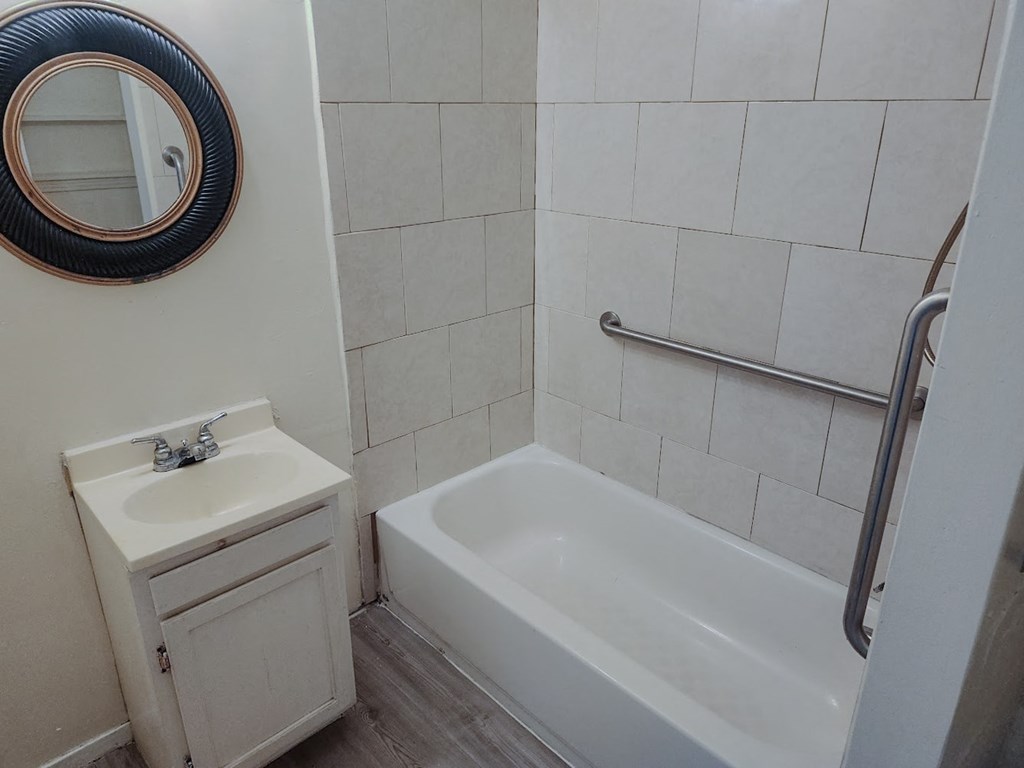 a bathroom with a sink and a tub and a mirror