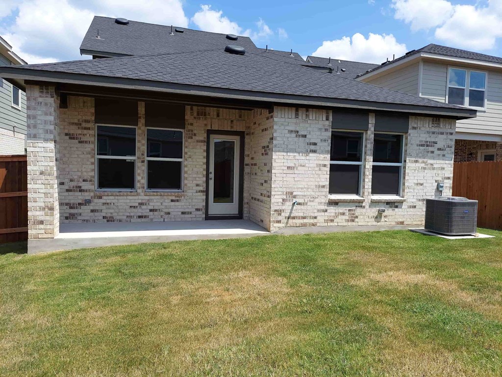 a brick house with a patio and a yard