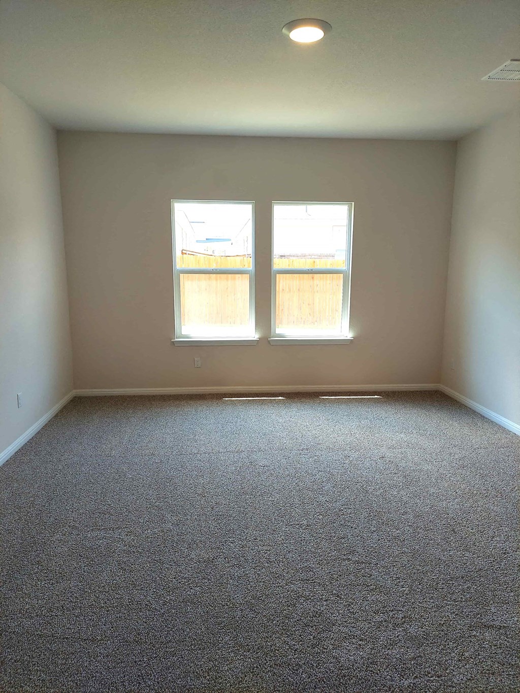 an empty room with two windows in it