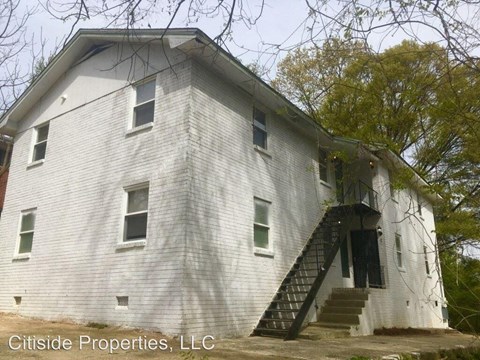 an old building with stairs  and trees