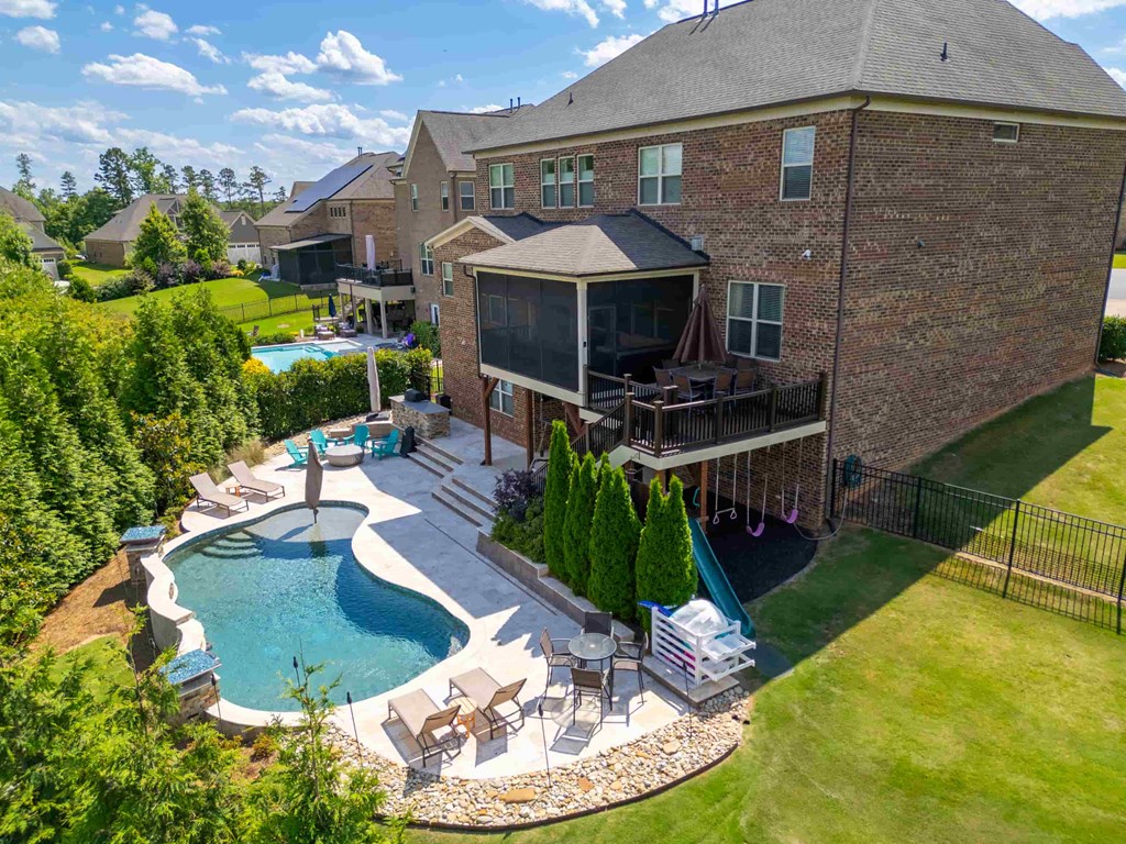 an aerial view of a backyard with a pool and a house