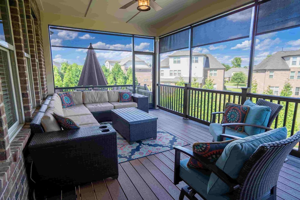 a screened in porch with a couch and chairs