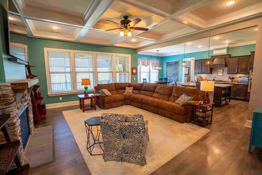 a large living room with a large couch and a ceiling fan