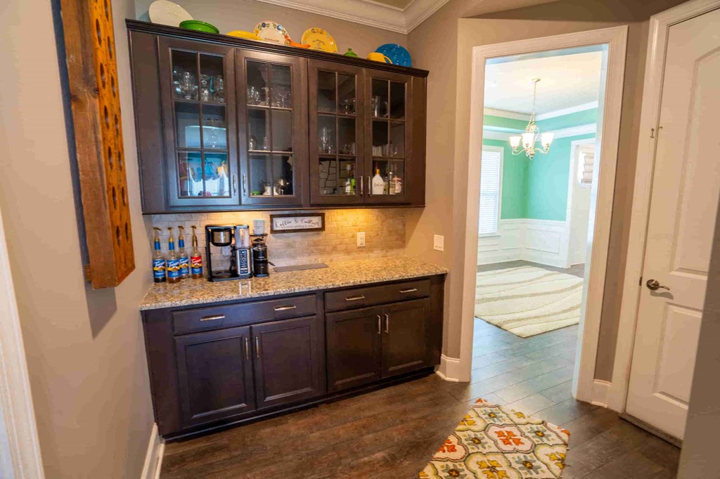 a kitchen with dark cabinets and a counter top and a hutch