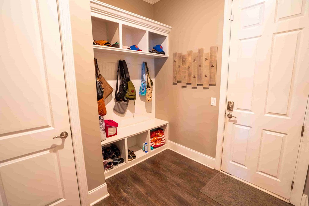 a closet with shoes and bags on shelves and a closet door