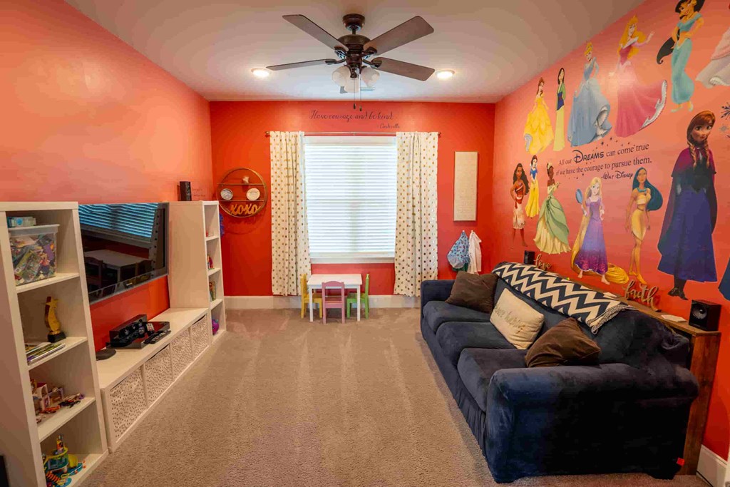 a halloween themed room with a couch and a ceiling fan