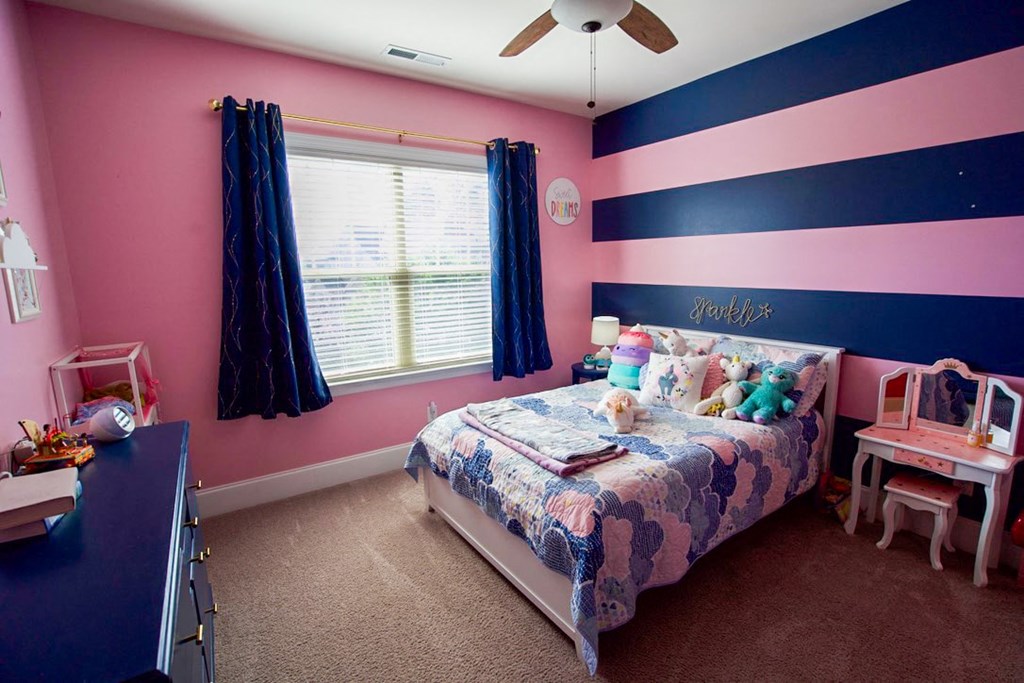 a bedroom with pink and blue walls and a bed