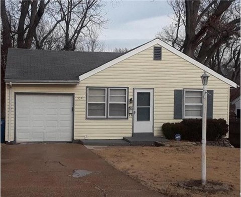 a yellow house with a white garage door
