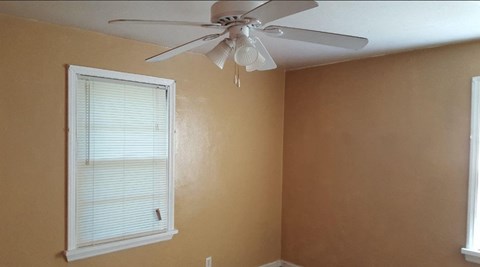 a bedroom with a ceiling fan and a window
