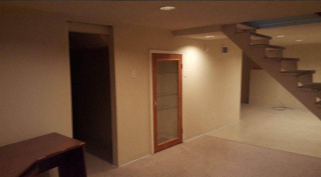 an empty room with a staircase and a door