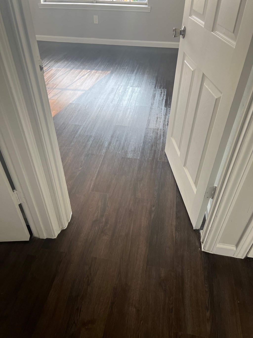 a living room with wooden floors and white doors