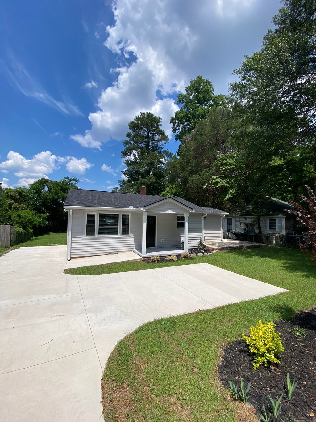 a white house with a driveway and a yard