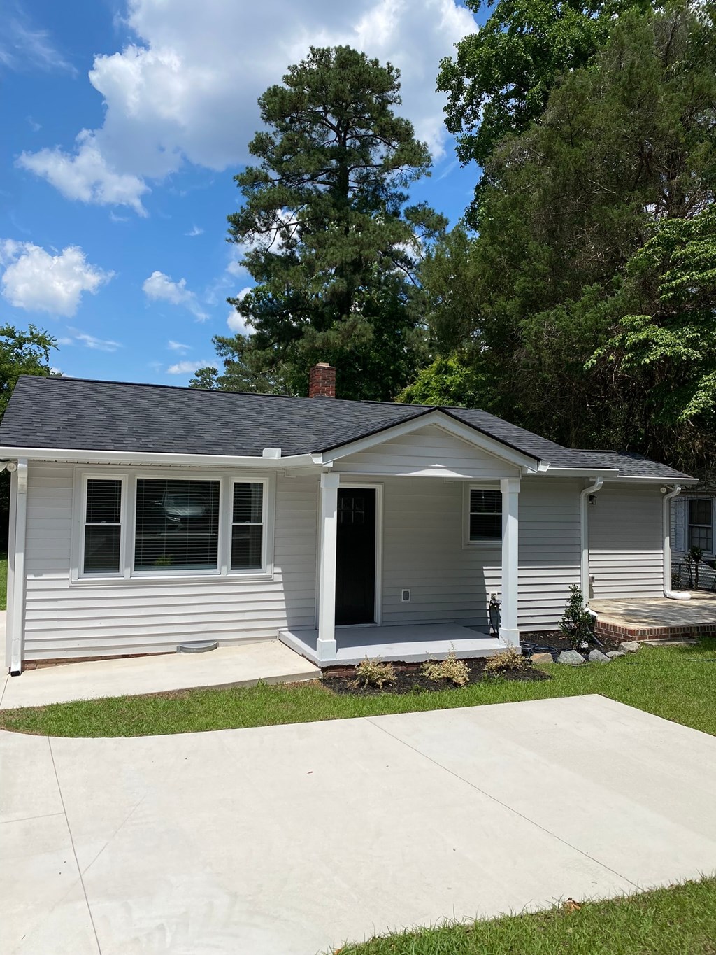a white house with a sidewalk in front of it