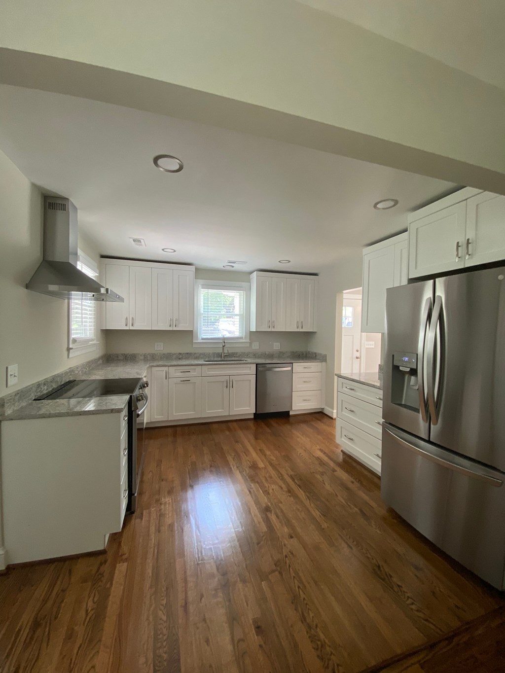an open kitchen with stainless steel appliances and white cabinets