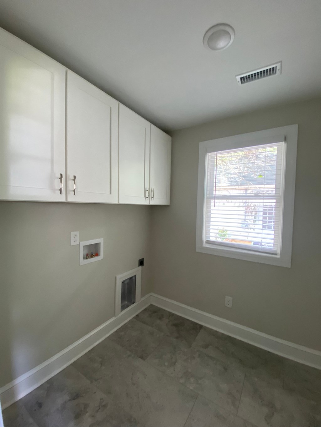 an empty room with white cabinets and a window