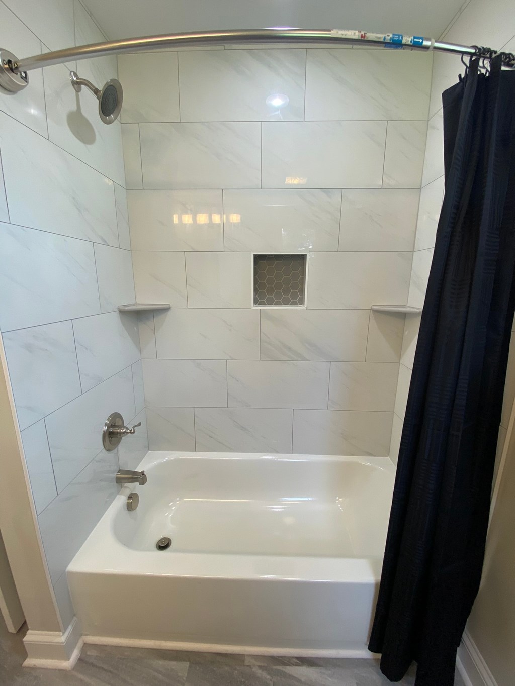 the shower has been tiled and the tub has a shower curtain