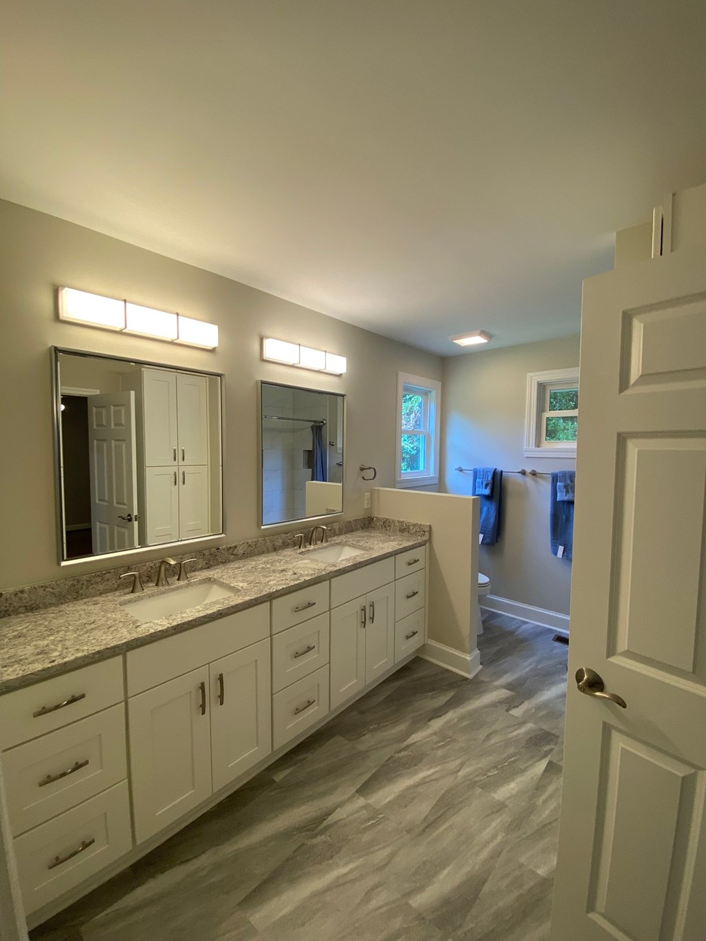a large bathroom with two sinks and two mirrors